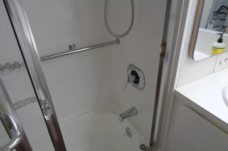 Ivory Lady Yacht Photos Pics Shower area in 1987 Hatteras 70 Cockpit Motor Yacht with chrome fixtures and white interior.