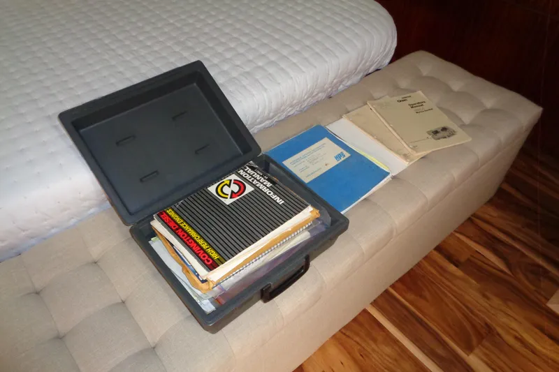 Ivory Lady Yacht Photos Pics Open box with manuals on a beige bench, Hatteras 70 Cockpit Motor Yacht, 1987.