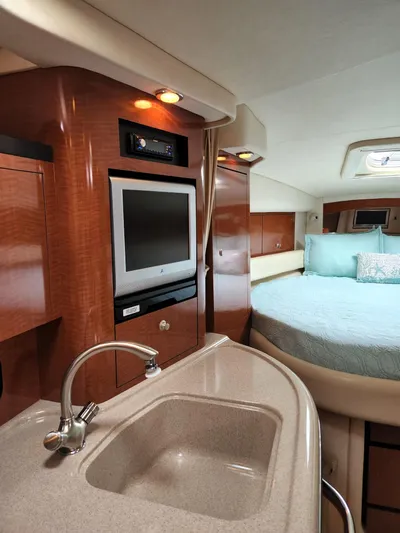  Yacht Photos Pics Luxurious 2005 Sea Ray 340 Sundancer cabin with sink, TV, and cozy bed.