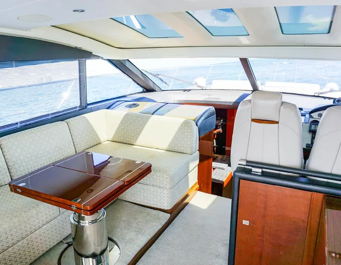 Bottoms Up Yacht Photos Pics Luxurious interior of 2015 Princess V52 yacht with elegant seating and panoramic windows.