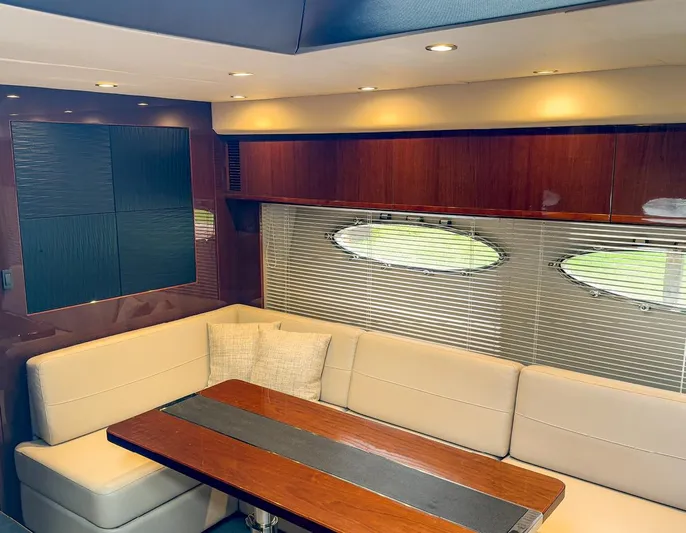 Bottoms Up Yacht Photos Pics Luxurious interior of 2015 Princess V52 yacht with elegant seating and wooden table.