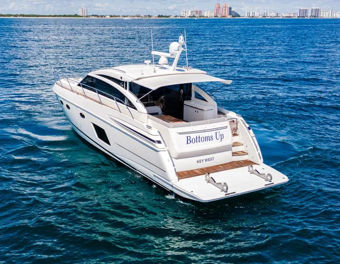 Bottoms Up Yacht Photos Pics 2015 Princess V52 yacht cruising on blue ocean near city skyline.