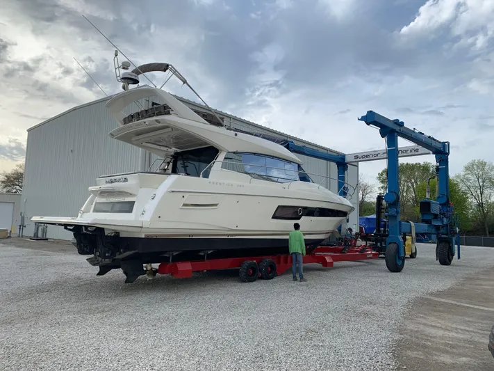 Margie Yacht Photos Pics 2018 Prestige 460 yacht on trailer near boatyard, under cloudy sky.
