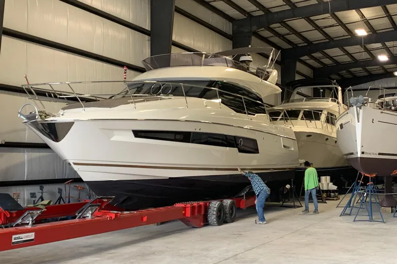 Margie Yacht Photos Pics 2018 Prestige 460 yacht in a storage facility with two people inspecting it.