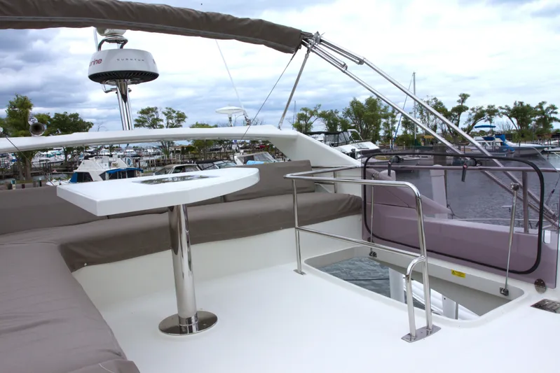 Margie Yacht Photos Pics Flybridge of 2018 Prestige 460 yacht with seating and table, docked at marina.