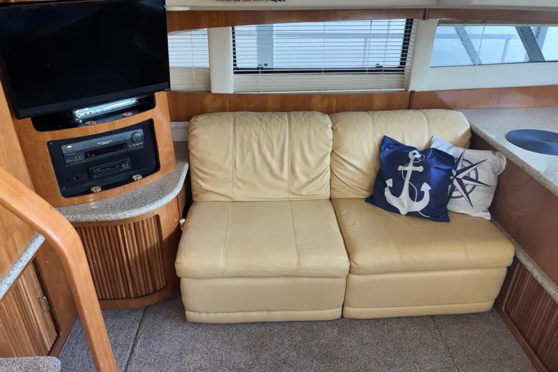  Yacht Photos Pics Interior of 2001 Carver 396 Motor Yacht with beige sofa, nautical pillows, and entertainment center.