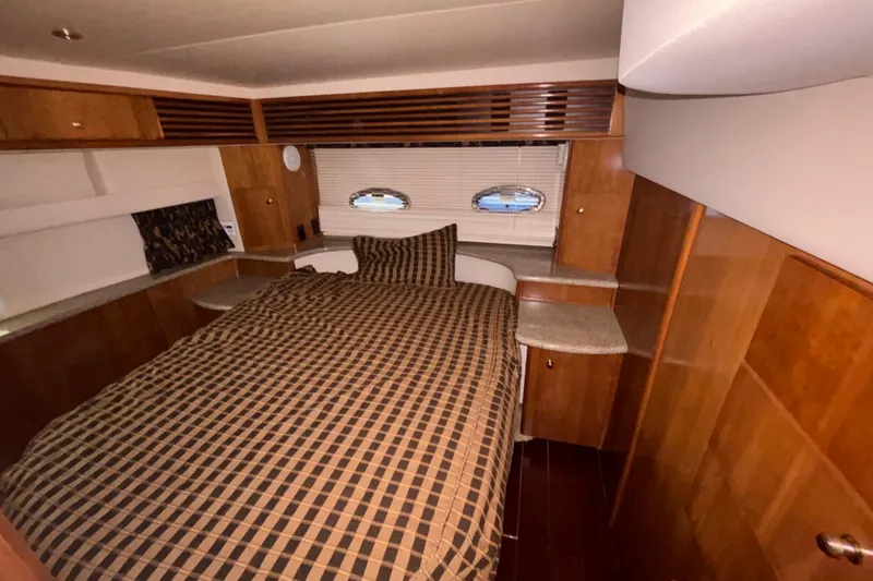  Yacht Photos Pics Interior of 2001 Carver 396 Motor Yacht bedroom with checkered bedding and wooden cabinetry.