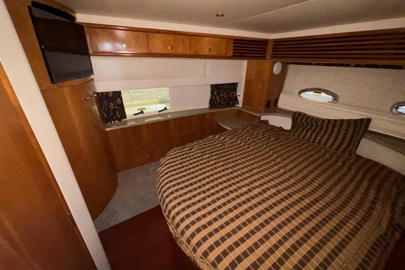  Yacht Photos Pics Luxurious 2001 Carver 396 Motor Yacht bedroom with wood cabinetry and plaid bedding.