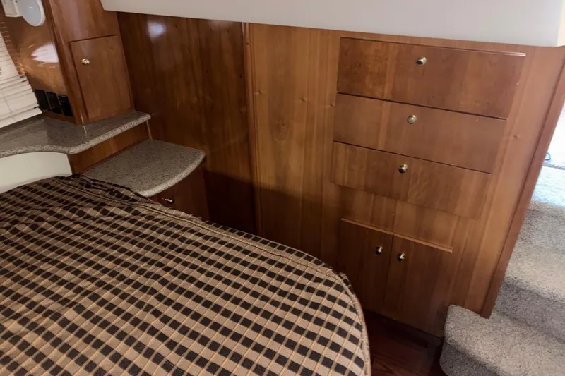  Yacht Photos Pics Interior of 2001 Carver 396 Motor Yacht with wood cabinetry and checkered bedding.