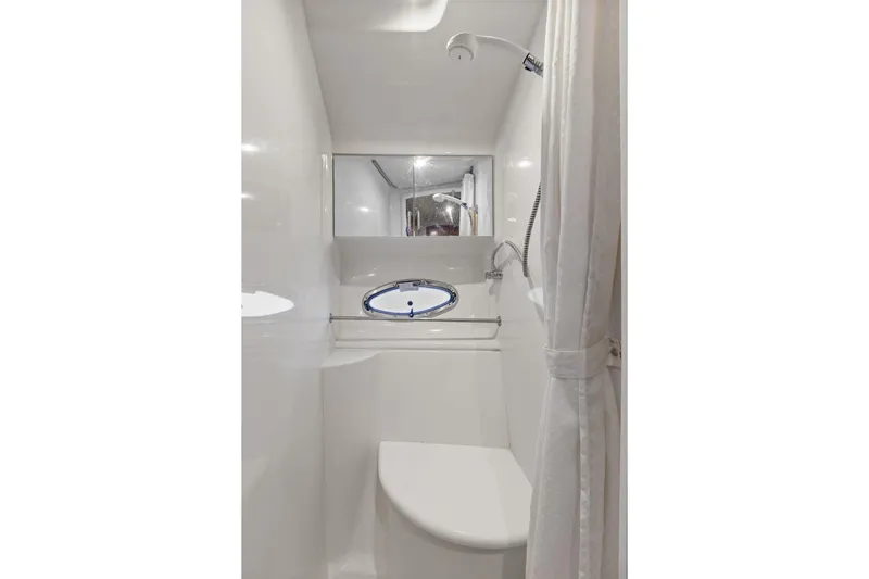  Yacht Photos Pics 2001 Carver 396 Motor Yacht bathroom with shower, white interior, and porthole window.