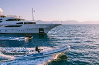 Luxury Benetti Custom yacht cruising with speedboats, 2008 model, on serene ocean waters.