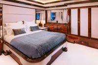 Luxurious bedroom interior on 2008 Benetti Custom yacht, featuring elegant wood finishes and plush bedding.