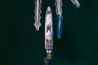 Aerial view of 2008 Benetti Custom yacht cruising on dark water.