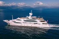 Luxurious 2008 Benetti Custom yacht cruising on open sea with scenic mountain backdrop.