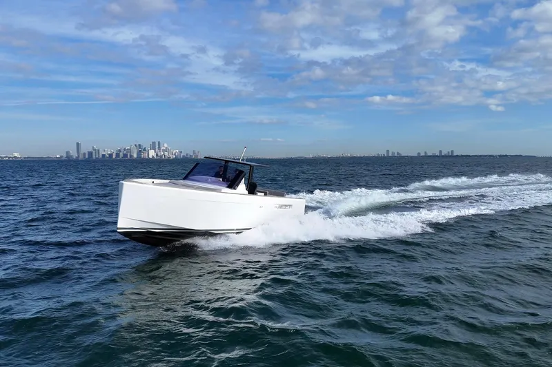  Yacht Photos Pics 2013 Fjord 40' Open yacht cruising on ocean with city skyline in background.