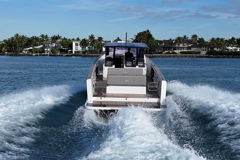  Yacht Photos Pics 2013 Fjord 40' Open yacht cruising on a sunny day near a tropical shoreline.