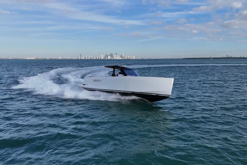  Yacht Photos Pics 2013 Fjord 40' Open yacht cruising on open water with city skyline in background.