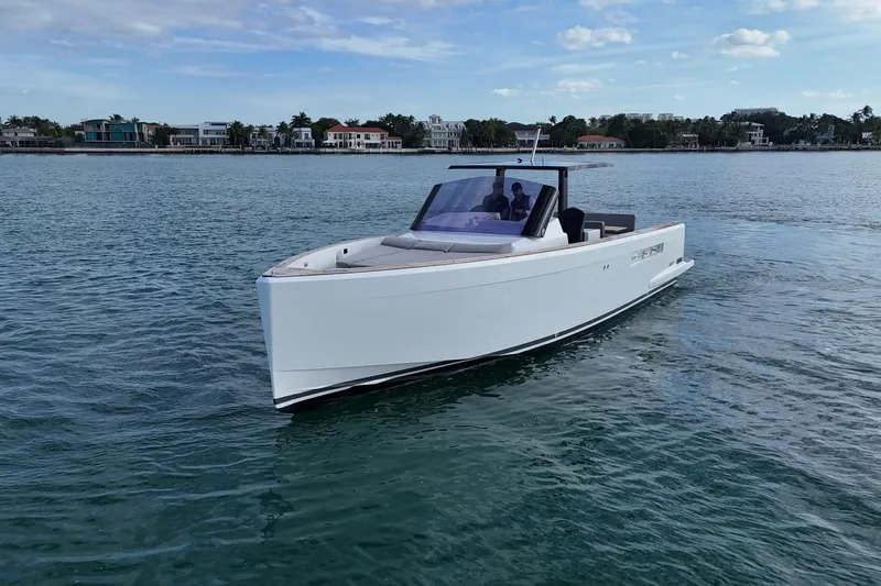  Yacht Photos Pics 2013 Fjord 40' Open yacht cruising on calm waters near coastal homes.