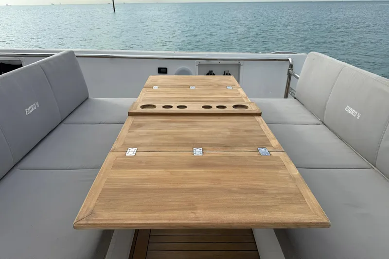  Yacht Photos Pics Luxury seating area on a 2013 Fjord 40' Open yacht with wooden table.