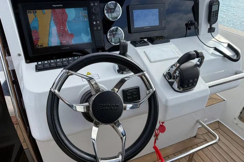  Yacht Photos Pics Control panel of a 2013 Fjord 40' Open boat with navigation screens and steering wheel.
