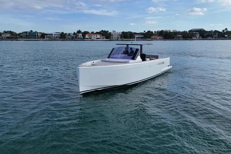  Yacht Photos Pics 2013 Fjord 40' Open yacht cruising on calm waters near coastal homes.