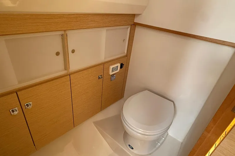  Yacht Photos Pics Compact bathroom in 2013 Fjord 40' Open yacht with wooden cabinetry and modern toilet.