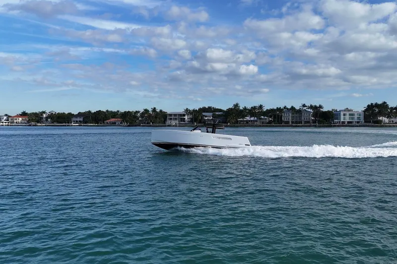  Yacht Photos Pics 2013 Fjord 40' Open yacht cruising on a sunny day near coastal homes.