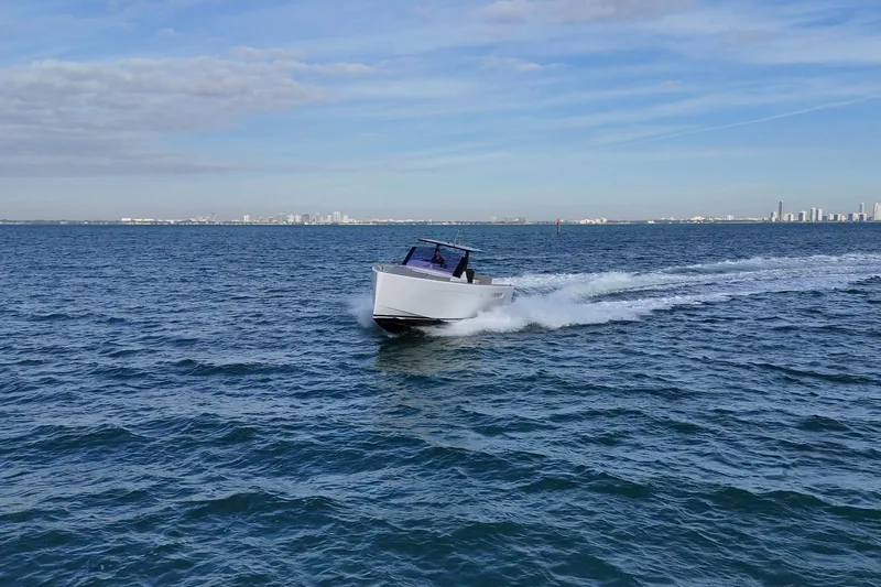  Yacht Photos Pics 2013 Fjord 40' Open cruising on open water with city skyline in background.