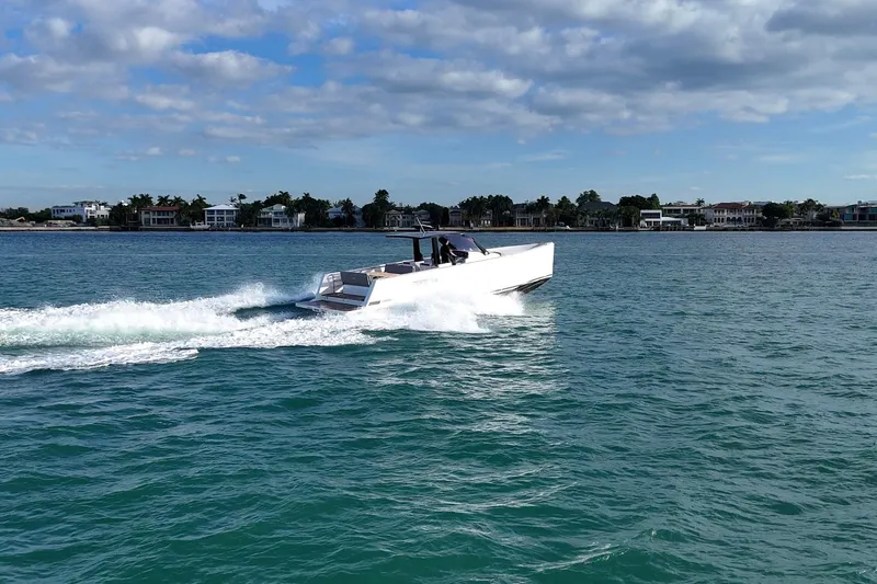  Yacht Photos Pics 2013 Fjord 40' Open yacht cruising on a sunny day near coastal homes.