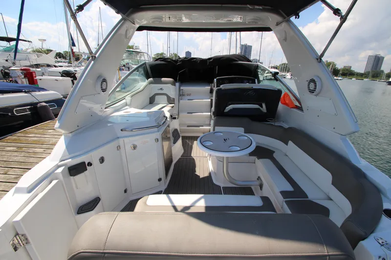  Yacht Photos Pics 2018 Monterey 295 Sport Yacht interior with seating and table, docked at marina.