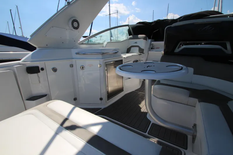  Yacht Photos Pics 2018 Monterey 295 Sport Yacht interior with seating, table, and cabinetry under sunny skies.