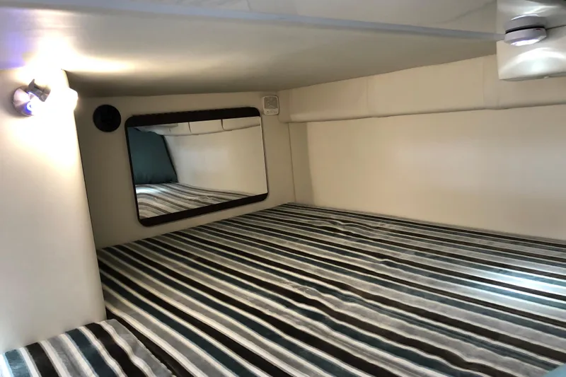  Yacht Photos Pics Interior cabin of 2018 Monterey 295 Sport Yacht with striped bedding and mirror.