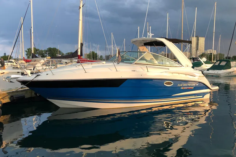  Yacht Photos Pics 2018 Monterey 295 Sport Yacht docked in a marina, reflecting on calm water.