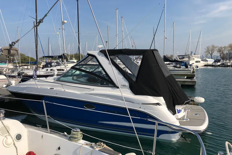  Yacht Photos Pics 2018 Monterey 295 Sport Yacht docked in a marina, surrounded by sailboats.