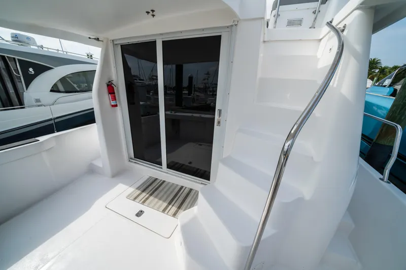Sea Bandit Yacht Photos Pics 2003 Mainship 390 Trawler deck with sliding door and staircase, featuring a fire extinguisher.