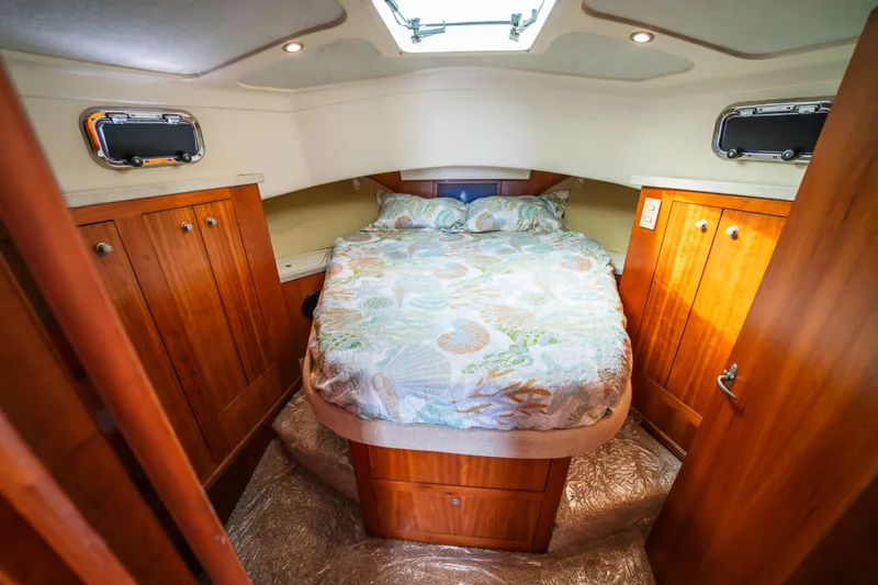 Sea Bandit Yacht Photos Pics Cozy cabin interior of 2003 Mainship 390 Trawler with bed and wooden cabinets.