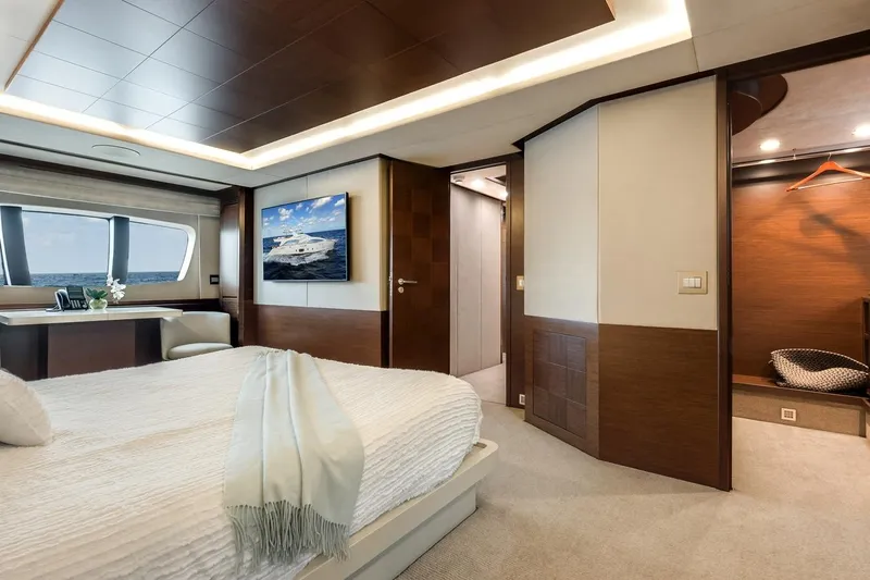 Amanecer Yacht Photos Pics Luxurious bedroom interior on 2009 Azimut 105 yacht, featuring elegant wood finishes and ocean view.
