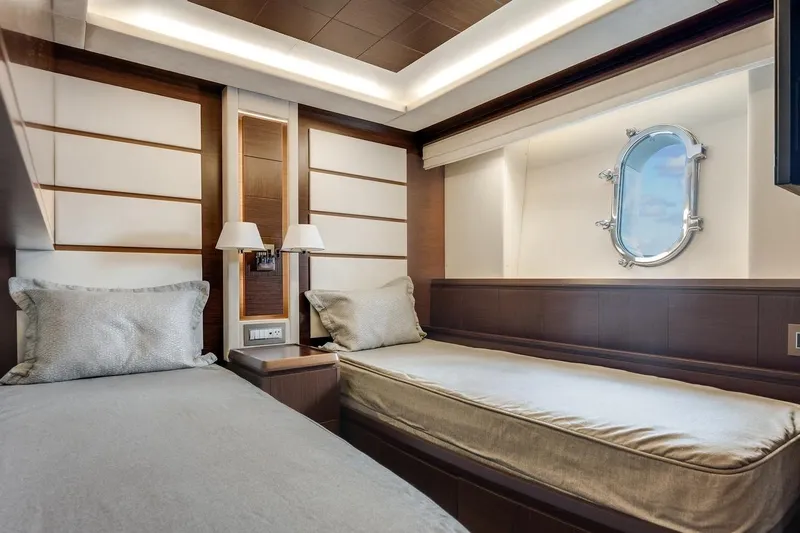 Amanecer Yacht Photos Pics Luxurious cabin interior of 2009 Azimut 105 yacht with twin beds and porthole window.