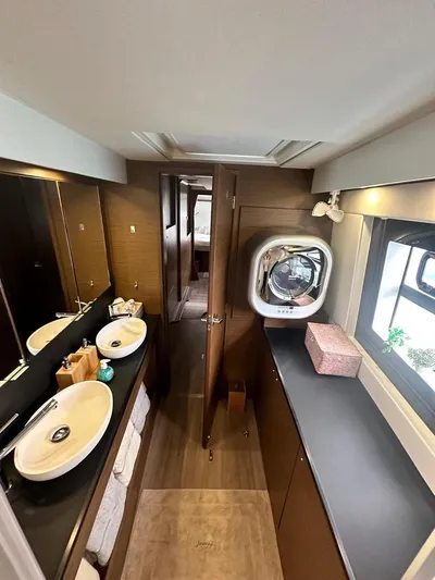 Hayat Yacht Photos Pics Modern bathroom interior of 2021 Nautitech 46 Fly catamaran with dual sinks and porthole.