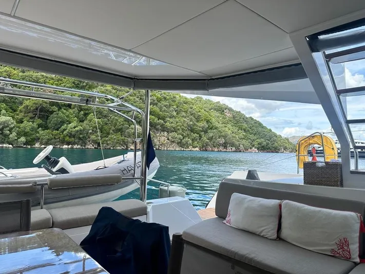 Hayat Yacht Photos Pics View from the Nautitech 46 Fly 2021 yacht, anchored near a lush, green coastline.