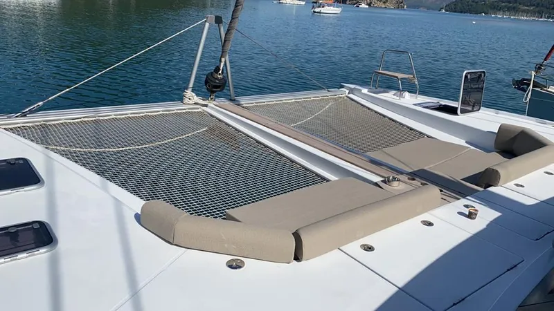 Hayat Yacht Photos Pics Nautitech 46 Fly 2021 catamaran with spacious deck and netting, anchored in serene waters.
