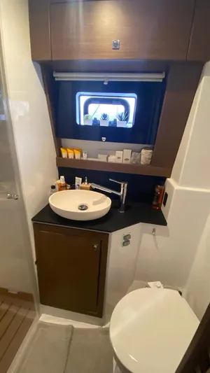 Hayat Yacht Photos Pics Modern bathroom in a 2021 Nautitech 46 Fly catamaran with sink, toilet, and window.