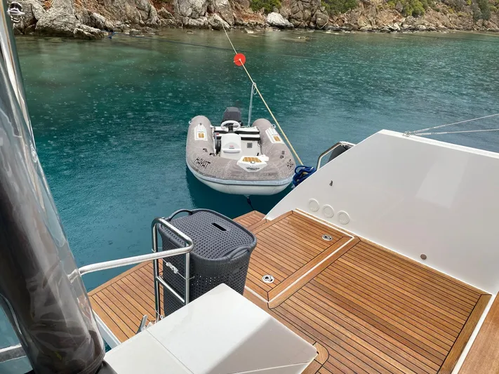 Hayat Yacht Photos Pics Nautitech 46 Fly 2021 yacht with wooden deck and inflatable dinghy in serene waters.