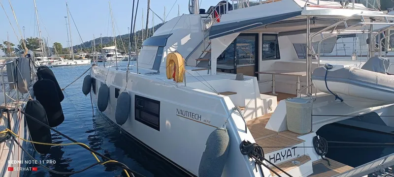 Hayat Yacht Photos Pics Nautitech 46 Fly 2021 catamaran docked at marina, featuring spacious deck and modern design.