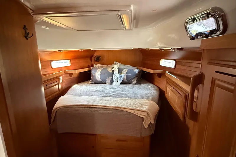 North Sound Yacht Photos Pics Cozy cabin interior of 2024 Tartan 455 yacht with wooden finish and comfortable bedding.