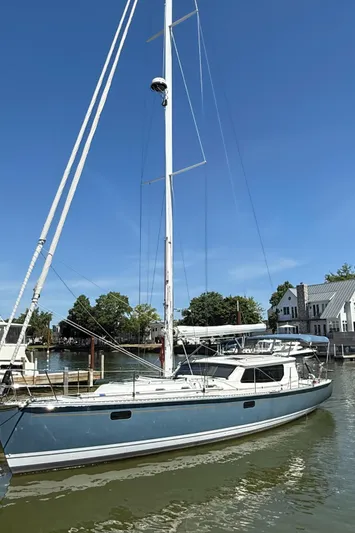 North Sound Yacht Photos Pics 2024 Tartan 455 sailboat docked in a marina, clear blue sky, waterfront homes in background.