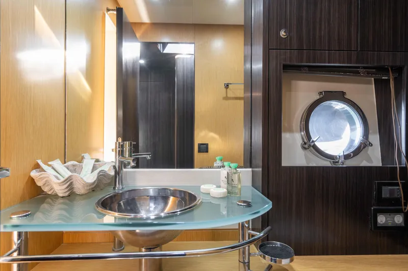  Yacht Photos Pics Luxurious bathroom interior of 2009 Riva 63 Vertigo yacht with modern sink and porthole.