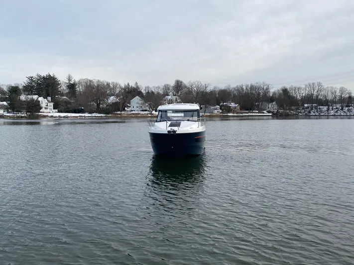  Yacht Photos Pics 2020 Beneteau Antares 9 boat on calm water with scenic shoreline background.