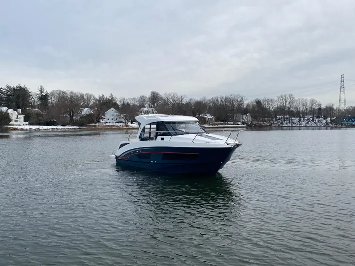  Yacht Photos Pics 2020 Beneteau Antares 9 boat on a calm lake with overcast sky.