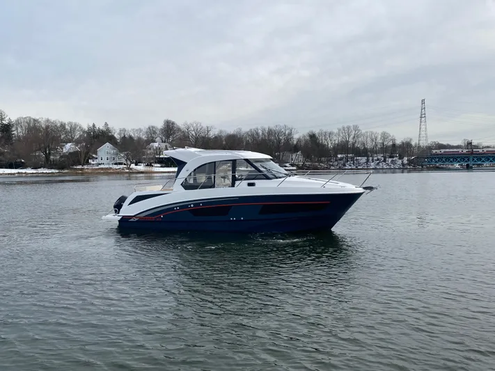  Yacht Photos Pics 2020 Beneteau Antares 9 boat cruising on a calm lake with a scenic background.